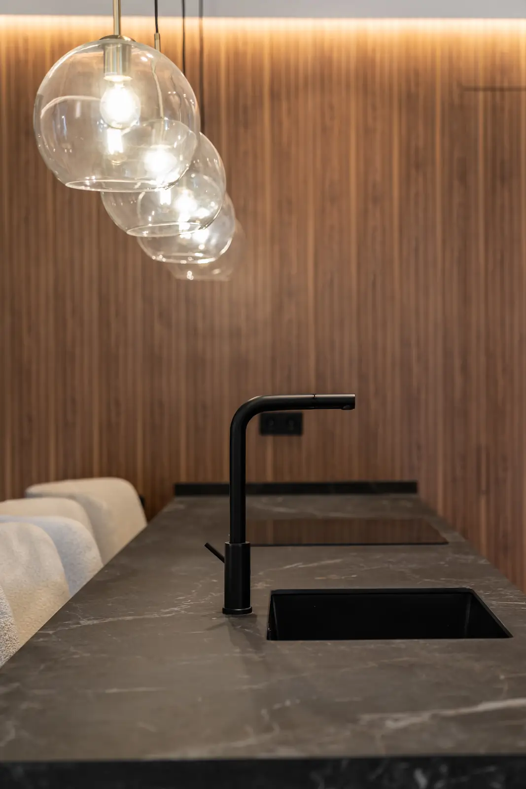 Detalle de cocina con lámparas de cristal y encimera de piedra negra